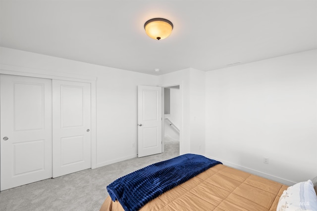 carpeted bedroom featuring baseboards and a closet