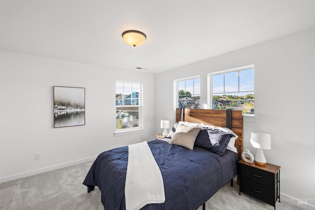 bedroom with light colored carpet and baseboards