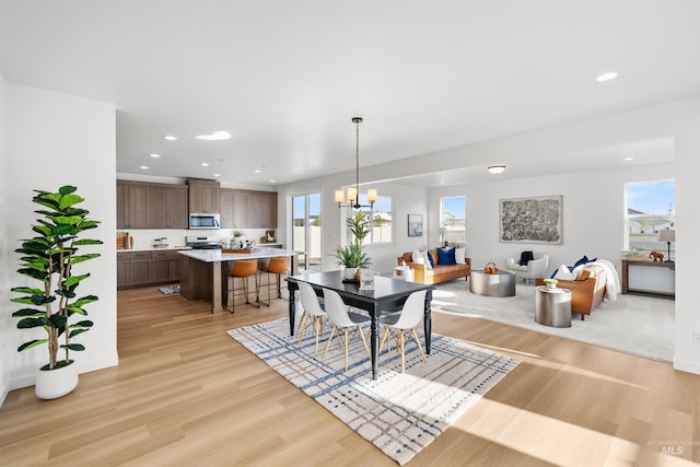 dining area with light wood finished floors, recessed lighting, and baseboards