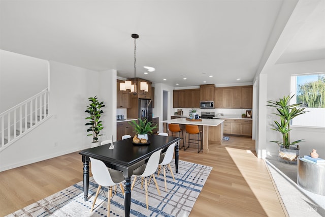 dining room with light wood-type flooring, a chandelier, stairway, recessed lighting, and baseboards