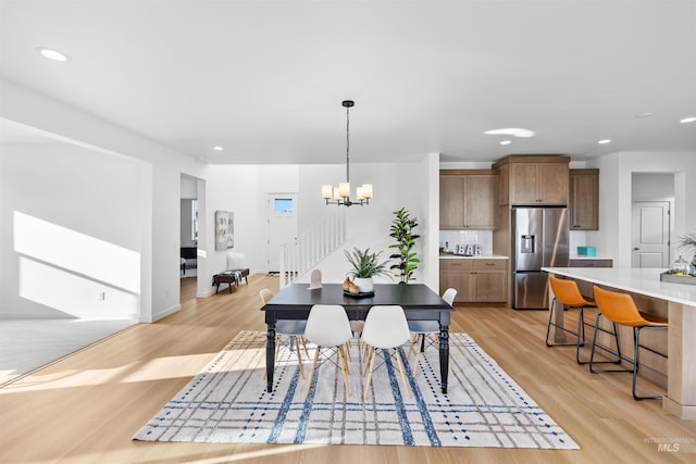 dining area featuring light wood-style flooring, a chandelier, stairway, recessed lighting, and baseboards