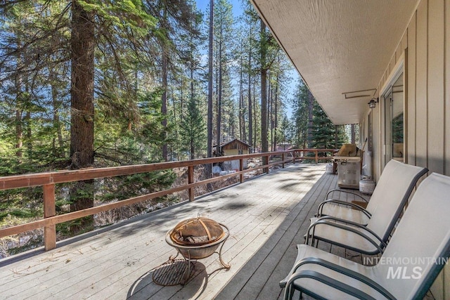 wooden terrace featuring a fire pit and grilling area