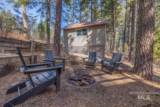 view of yard with an outdoor fire pit, an outbuilding, a storage unit, and fence