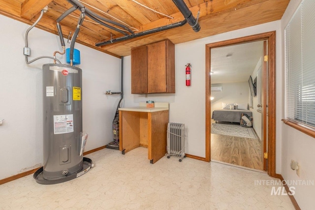 below grade area featuring water heater, baseboards, and light floors