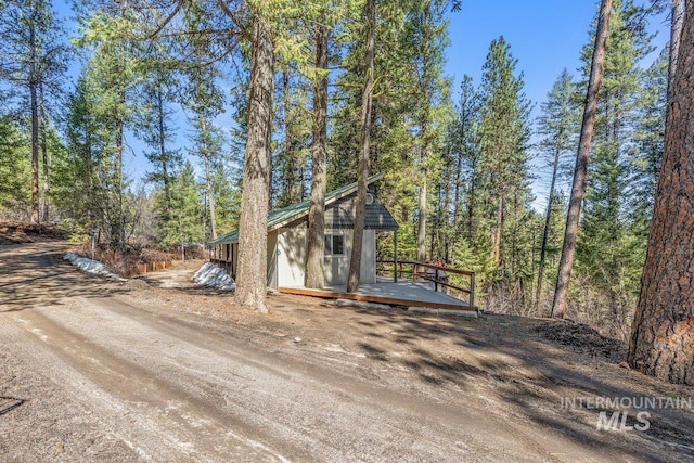 exterior space with a wooded view and a wooden deck