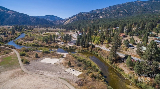 drone / aerial view with a view of trees and a water and mountain view