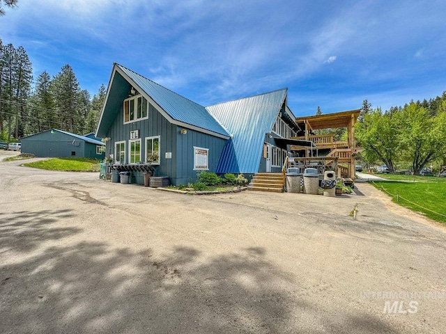 rear view of house featuring metal roof and board and batten siding