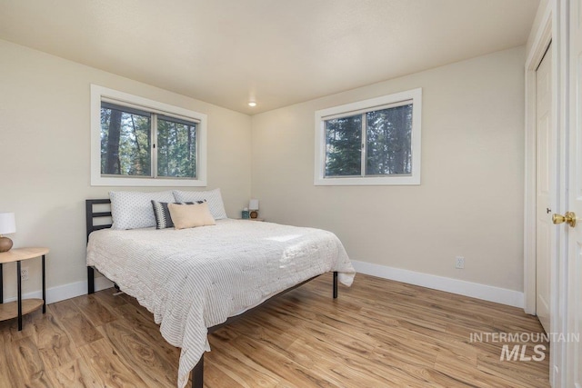 bedroom featuring baseboards and wood finished floors