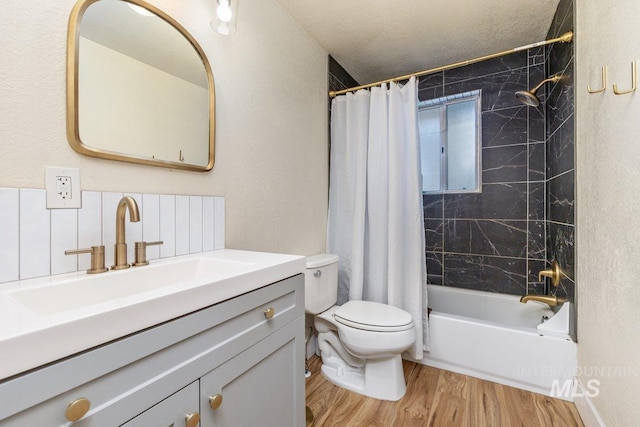 full bath featuring toilet, a textured ceiling, shower / bathtub combination with curtain, vanity, and wood finished floors
