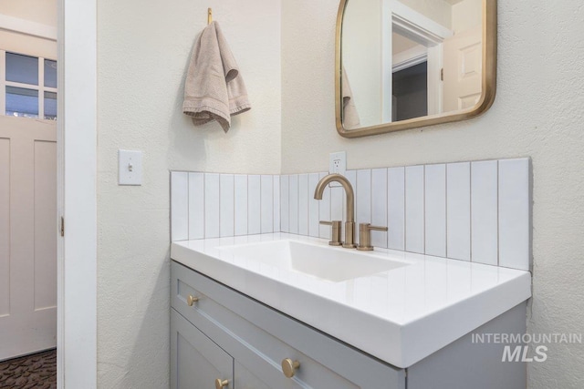 bathroom featuring vanity and a textured wall
