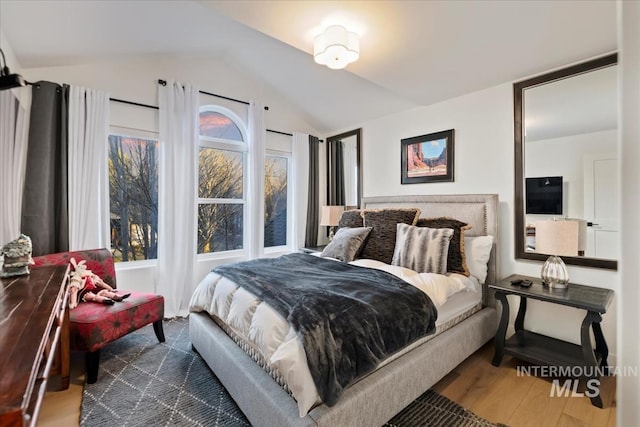 bedroom featuring lofted ceiling and wood finished floors