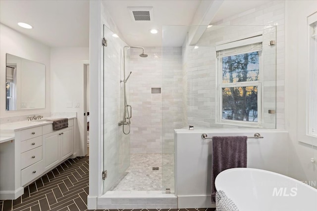 bathroom with recessed lighting, visible vents, a freestanding bath, a stall shower, and vanity