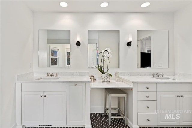 full bath featuring recessed lighting, two vanities, and a sink