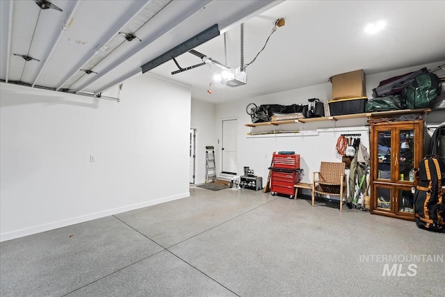 garage featuring a garage door opener and baseboards