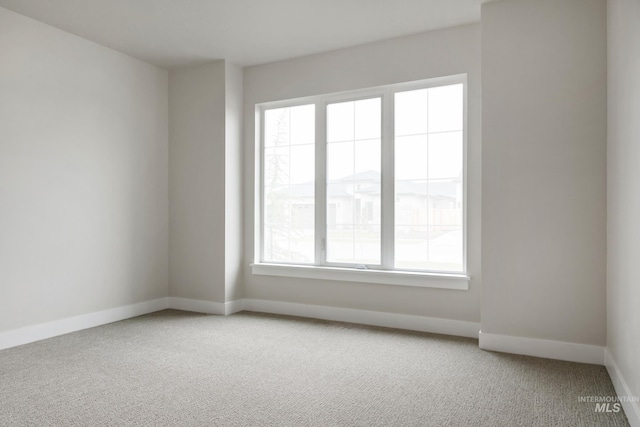 carpeted spare room featuring baseboards