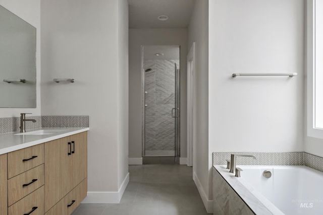 full bath with a stall shower, vanity, baseboards, a bath, and tile patterned floors