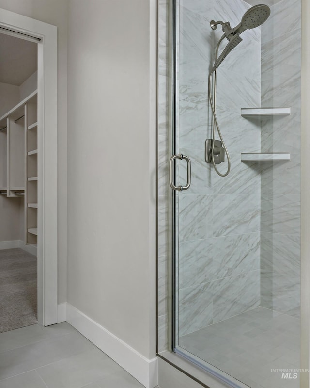 full bath featuring a stall shower and baseboards