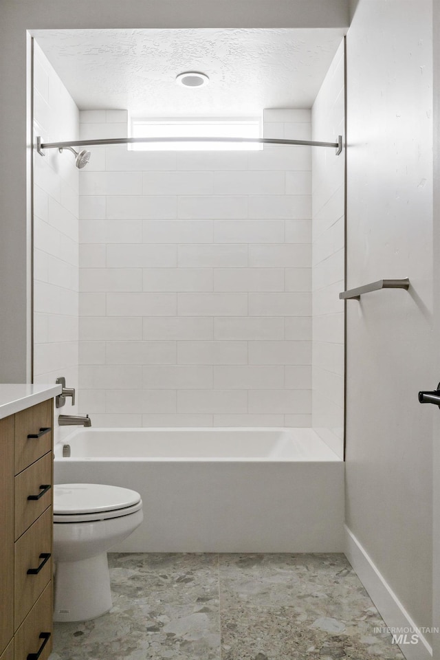 bathroom featuring a textured ceiling, vanity, toilet, and bathing tub / shower combination