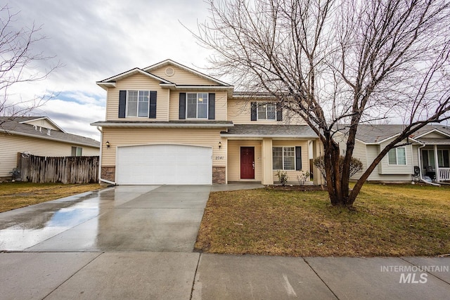 traditional-style house featuring concrete driveway, stone siding, an attached garage, fence, and a front lawn