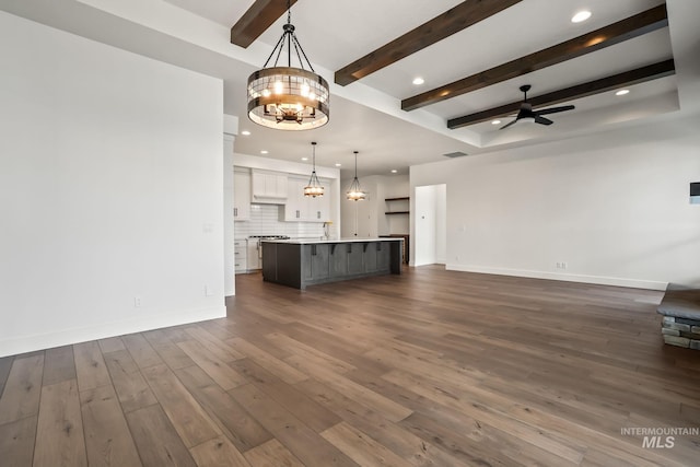 unfurnished living room with dark wood-type flooring, beamed ceiling, and ceiling fan with notable chandelier