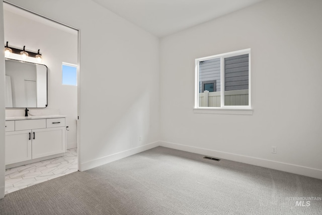 carpeted spare room featuring sink