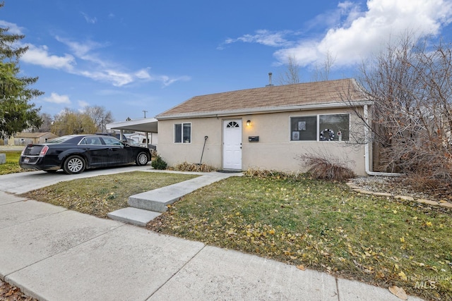 view of front of home with a front yard and a carport