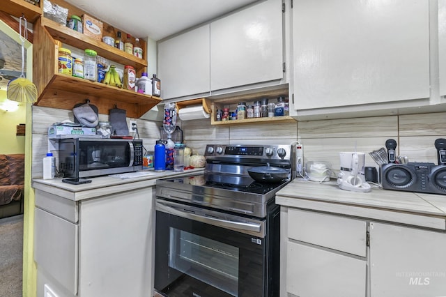 kitchen featuring tasteful backsplash, white cabinets, and stainless steel appliances