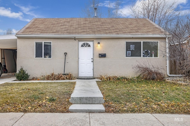 bungalow featuring a front yard and a carport