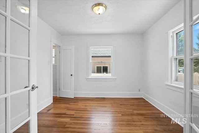 101 E 2nd St, Emmett, ID 83617 - empty room with plenty of natural light, wood finished floors, a textured ceiling, and french doors
