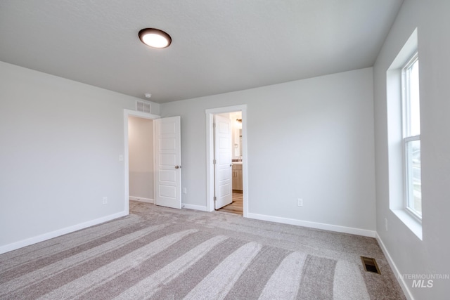 2839 N Rocky Bottom Way, Kuna, ID 83634 - unfurnished bedroom featuring baseboards, multiple windows, visible vents, and light colored carpet