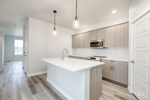 2839 N Rocky Bottom Way, Kuna, ID 83634 - kitchen featuring modern cabinets, a sink, backsplash, stainless steel appliances, and a kitchen island with sink