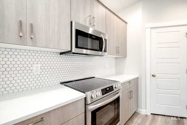 2839 N Rocky Bottom Way, Kuna, ID 83634 - kitchen with light wood-style floors, decorative backsplash, light brown cabinetry, and appliances with stainless steel finishes