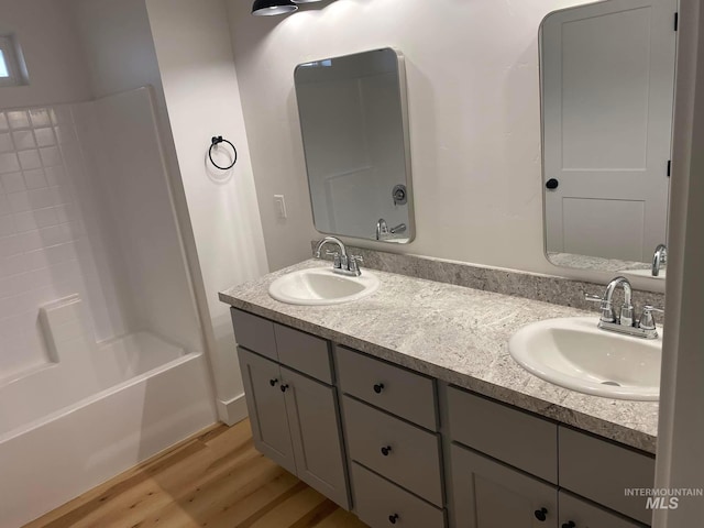 bathroom with bathing tub / shower combination, vanity, and hardwood / wood-style floors