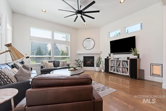3023 E Tusa St, Meridian, ID 83642 - living area featuring a ceiling fan, recessed lighting, a glass covered fireplace, wood finished floors, and baseboards