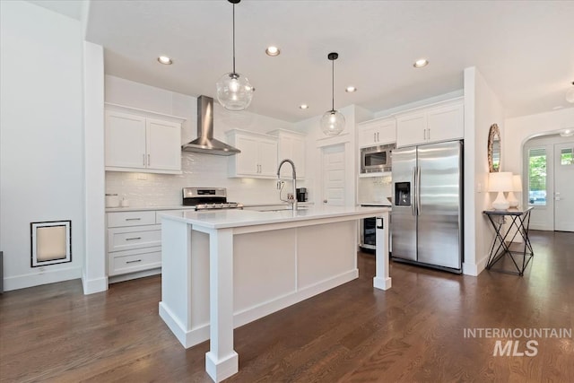 3023 E Tusa St, Meridian, ID 83642 - kitchen with appliances with stainless steel finishes, wall chimney range hood, a sink, decorative backsplash, and dark wood finished floors