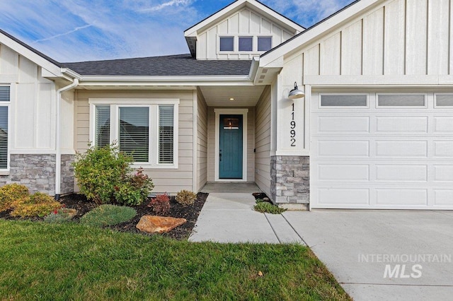 view of exterior entry featuring a garage and a lawn