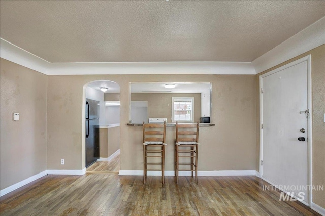 904 N 9th Ave, Buhl, ID 83316 - unfurnished dining area featuring wood finished floors, arched walkways, a textured ceiling, and baseboards