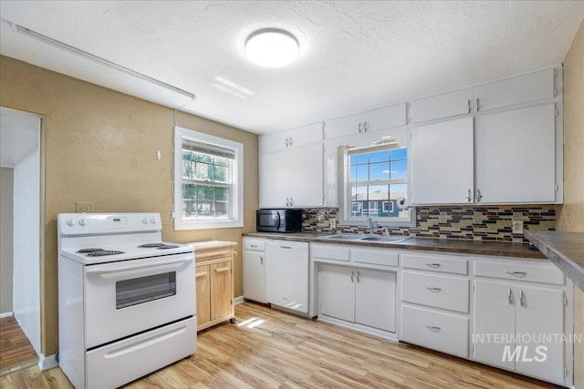 904 N 9th Ave, Buhl, ID 83316 - kitchen with white appliances, a sink, backsplash, light wood finished floors, and white cabinetry