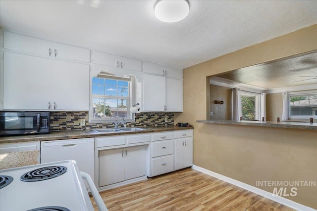 904 N 9th Ave, Buhl, ID 83316 - kitchen featuring white appliances, a sink, backsplash, white cabinets, and light wood-style floors