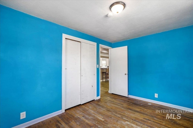 904 N 9th Ave, Buhl, ID 83316 - unfurnished bedroom featuring baseboards, a closet, wood finished floors, and a textured ceiling