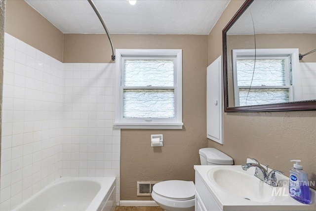 904 N 9th Ave, Buhl, ID 83316 - bathroom featuring toilet, vanity, washtub / shower combination, and a textured wall