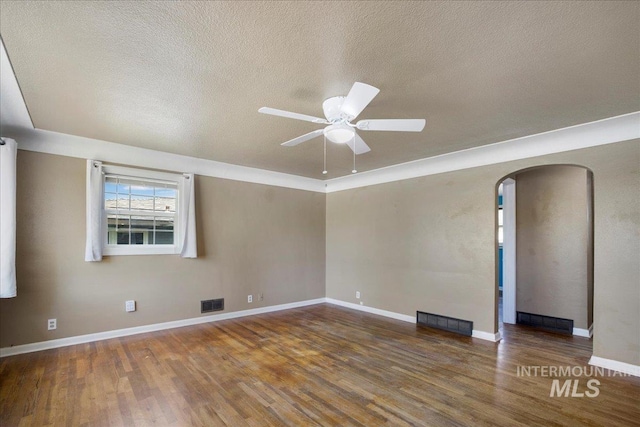 904 N 9th Ave, Buhl, ID 83316 - spare room featuring arched walkways, a ceiling fan, wood finished floors, a textured ceiling, and baseboards