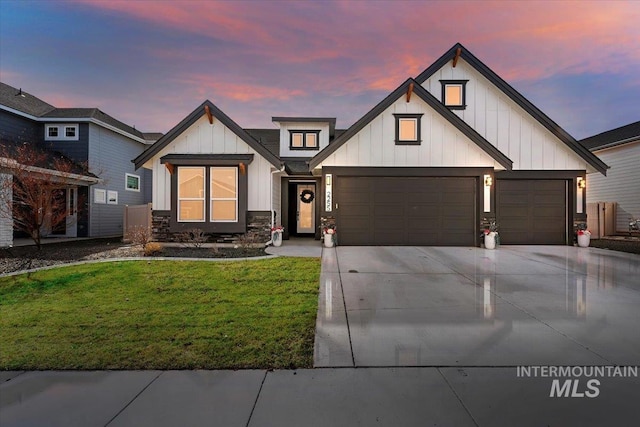 modern farmhouse with a yard, board and batten siding, driveway, and a garage