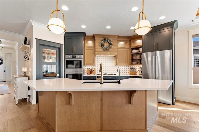 kitchen with crown molding, stainless steel appliances, light countertops, and a sink