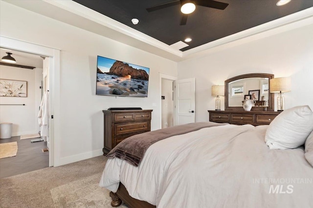 bedroom with a raised ceiling, recessed lighting, carpet floors, crown molding, and baseboards