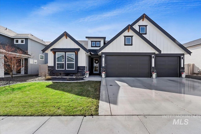 modern farmhouse style home with concrete driveway, a garage, board and batten siding, and a front lawn