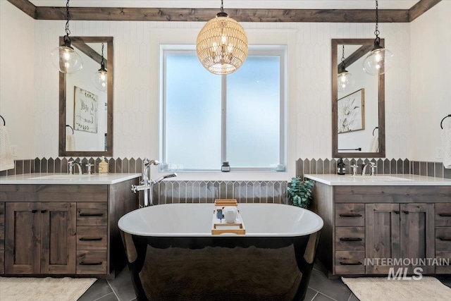 bathroom with tile patterned floors, a freestanding tub, and a sink