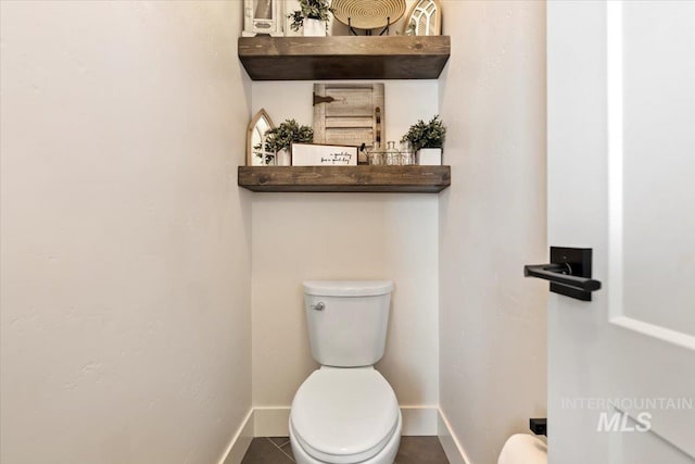 bathroom with tile patterned flooring, toilet, and baseboards