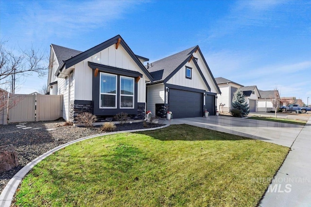 modern farmhouse with a front lawn, driveway, a gate, stone siding, and board and batten siding