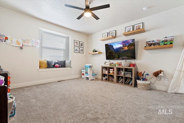 game room with a textured ceiling, baseboards, carpet floors, and ceiling fan